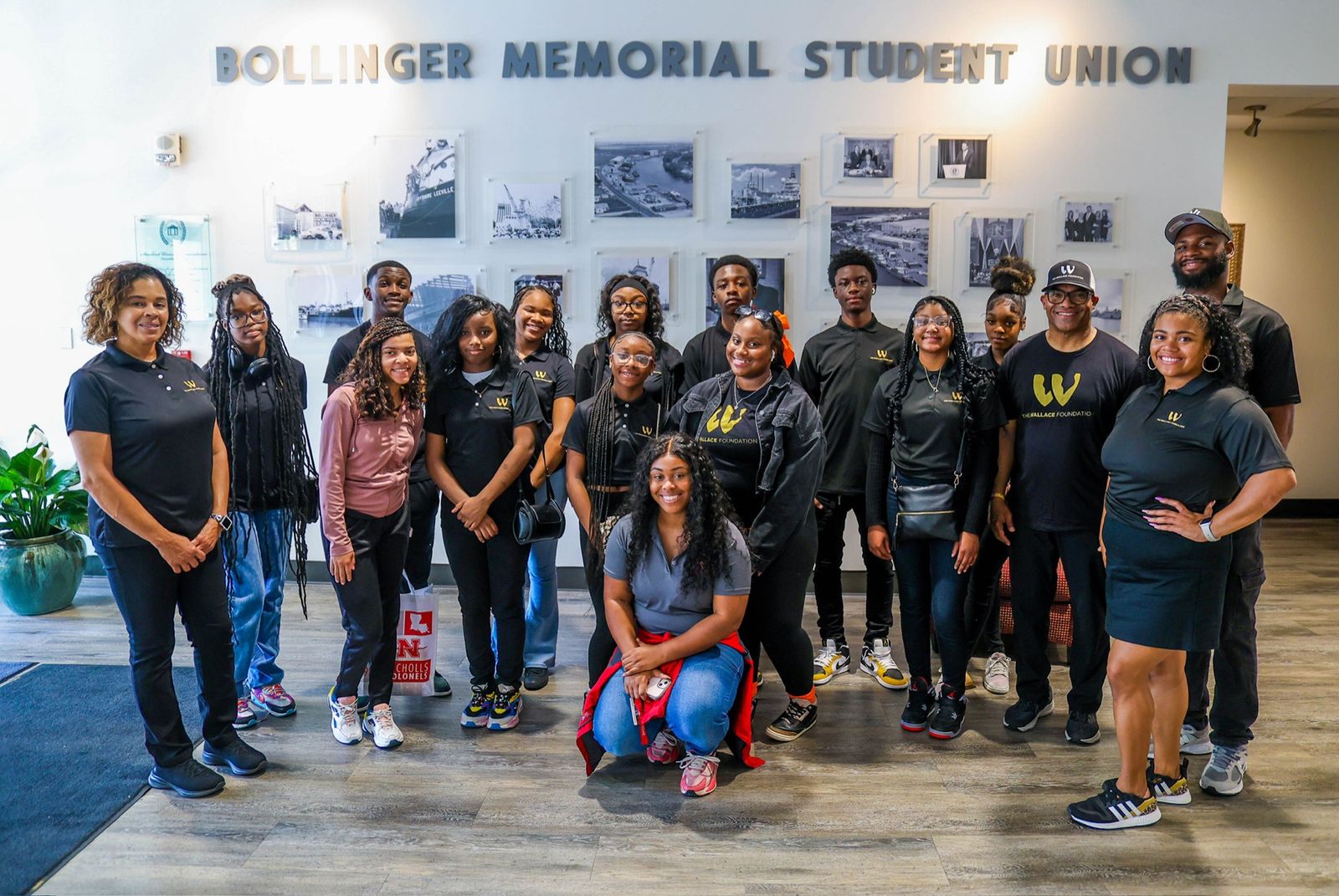 Students and Foundation staff in Wallace Foundation shirts, gathered in the lobby of the Bollinger Memorial Student Union during a college campus visit.